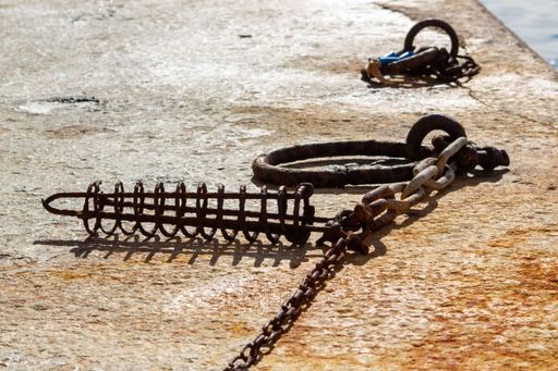 A set of chains, shackles, and whips on the edge of a rocky surface