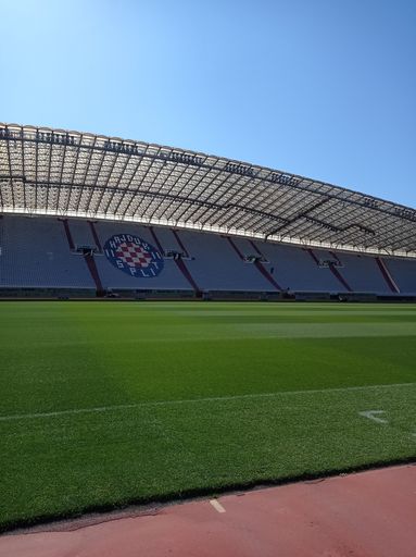 A lush green soccer field with the audience seats throughout the stadium