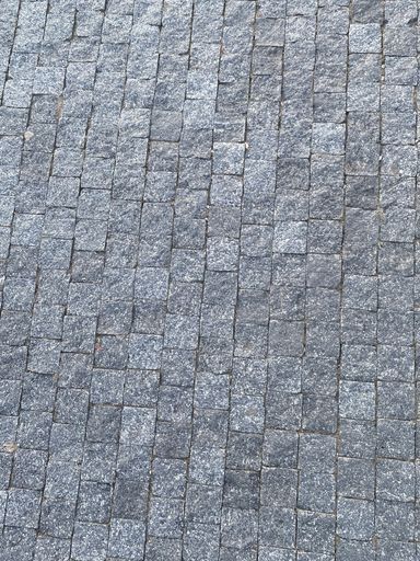 A closeup vertical shot of a gray cobblestone road texture background