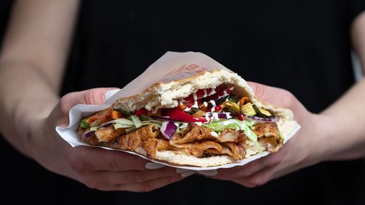 A delicious Berliner doner kebab with fresh turkey and chicken, mixed salad with tomatoes, vegetables and garlic sauce