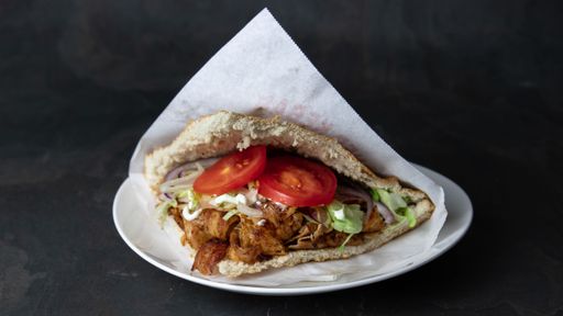 A delicious Berliner doner kebab with fresh turkey and chicken, mixed salad with tomatoes, vegetables and garlic sauce