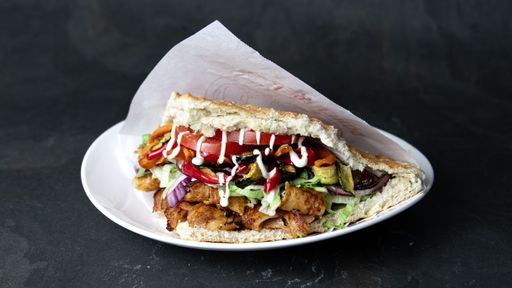 A delicious Berliner doner kebab with fresh turkey and chicken, mixed salad with tomatoes, vegetables and garlic sauce