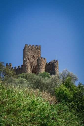 A beautiful shot of the majestic Alm Castle under a bright blue sky in Portugal