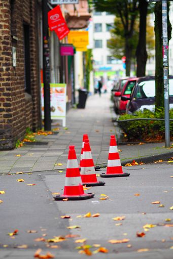 A vertical shot of three traffic cones next to each other on the street