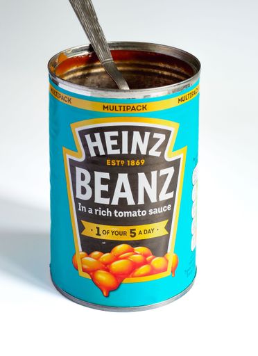 Open can of Heinz Beans with a silver spoon sticking out