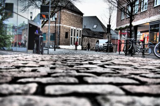 A low angle shot of the ground tiles and buildings surrounded by people