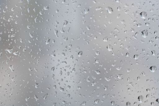 Closeup shot of rain droplets forming on the glass window pane