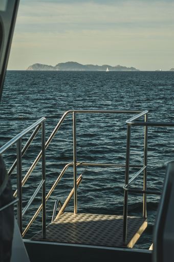 A scenic view of the mountains from a boat on a tranquil body of water, with a clear blue sky in the background