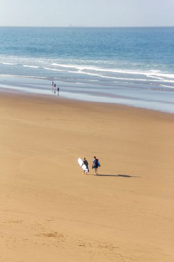The surfers walking on the beach in Taghazout, Morocco.