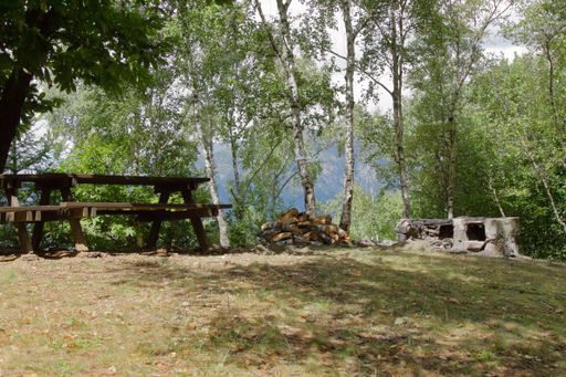 A pic nic area in the italian alps with wood table and raw stone barbeque HQ photo.