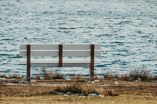 An Rear view of the single romantic wooden  bench by the sea for the background