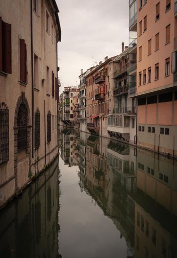 A picturesque alleyway with colorful buildings and a canal running through it in Padova, Italy