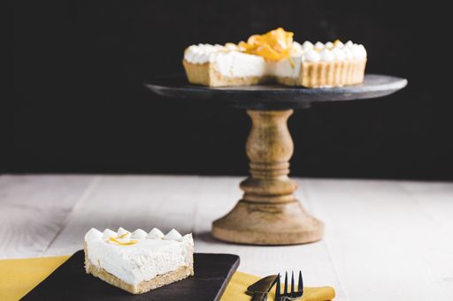 A beautiful shot of a creamy pie on the stand and a slice next to it