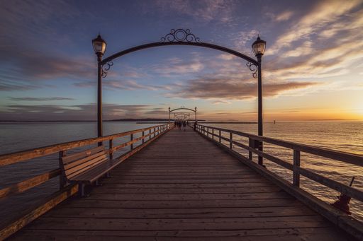 A pier and the blue sea during a scenic sunset