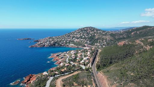 An aerial view of a highway winding through a coastal landscape of Massif de l'Esterel mountain on the French Riviera
