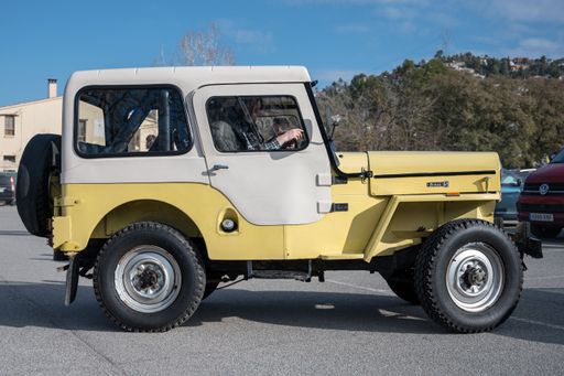 Side view of a classic off-road Jeep Ebro CJ-3B-E Bravo S in yellow color