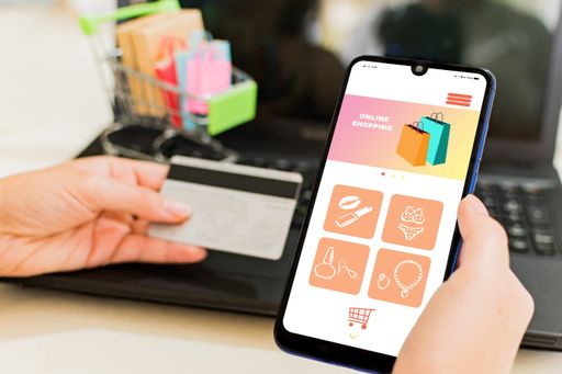 A selective focus of a hand holding a smartphone showing a shopping service app