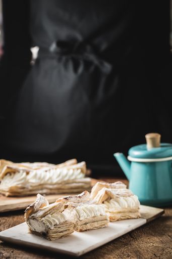 A vertical shot of creamy dessert and a blue teapot