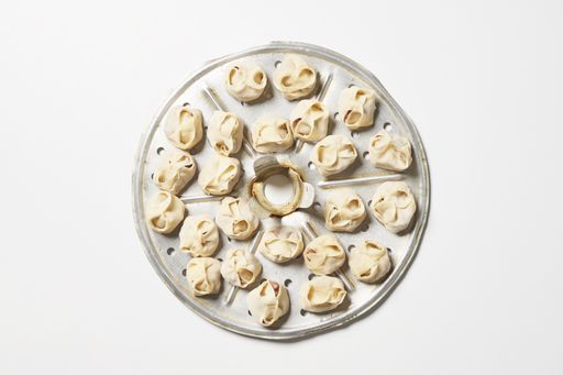 A top view of delicious homemade manti dumplings on a white surface