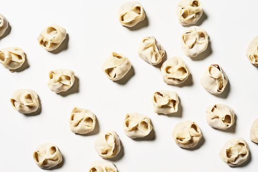 A top view of delicious homemade manti dumplings on a white surface