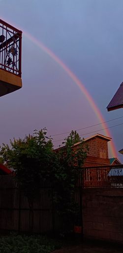 This stunning image captures a vibrant rainbow stretching across a suburban landscape