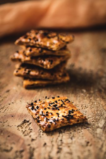 A beautiful shot of crackers and a blue teapot on the wooden surface