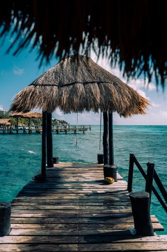 A picturesque wooden dock jutting out over the calm, blue waters of the ocean