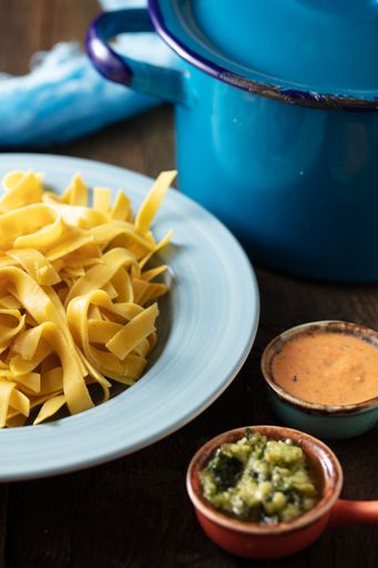 A closeup shot of fettuccine and sauces next to it