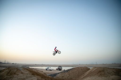 Freestyle motorcross riders and motorbikes in the desert jumping of dunes