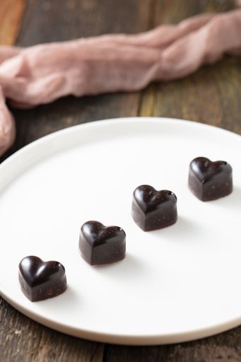 A top view shot of blackheart shaped cholates on the white plate