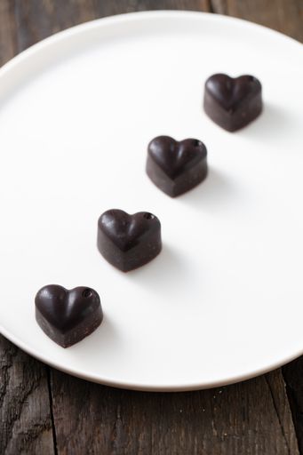 A top view shot of blackheart shaped cholates on the white plate