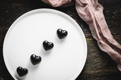A top view shot of blackheart shaped cholates on the white plate