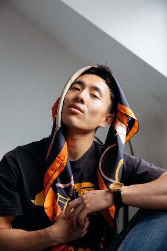 A vertical shot of an attractive young Asian male model posing indoors