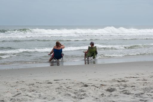 Two women sitting on beach chairs in the surf at Myrtle Beach, SC
