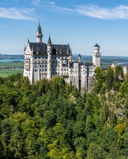 An aerial view of the historic Neuschwanstein Castle surrounded by lush greenery