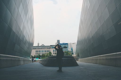 A photographer taking photos standing between two stone structures