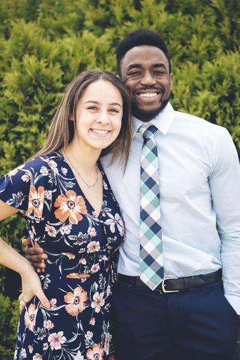 A beautiful young couple posing on green thuja background
