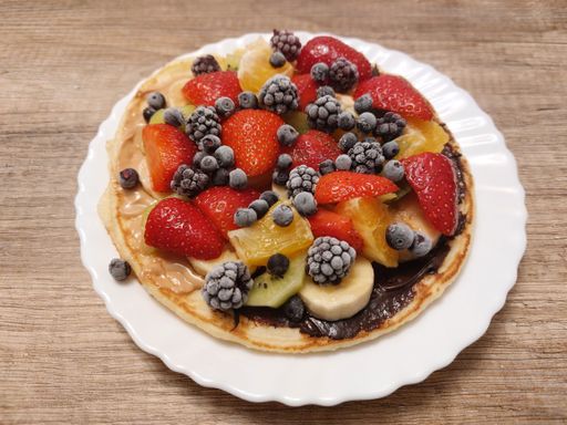 A closeup shot of a pancake with fruits.