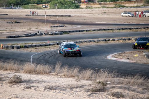cars on tarmac tack drag racing with smoke in desert during day time