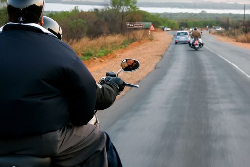 old motorcycles riding together with passengers on the tarmac