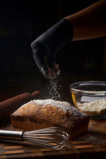 A closeup shot of a loaf of bread being dusted with flour.