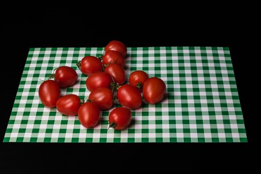 Fresh ripe delicious cherry tomatoes on a green checkered tablecloth