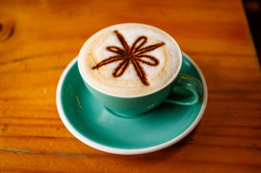 A closeup of a ceramic cup filled with creamy coffee at a cafe