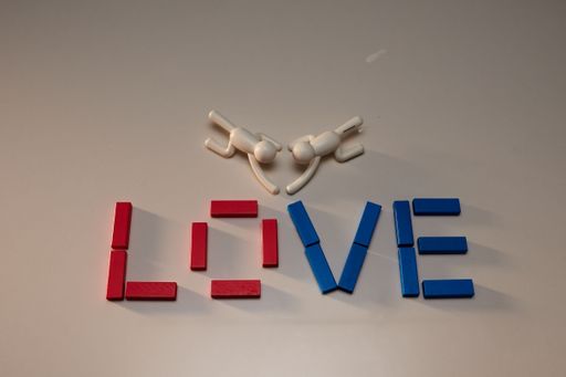 A colorful array of plastic blocks arranged to spell out the word 'love' with two toy figures