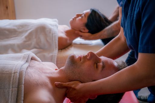 couple massaged, by two male and female masseurs, doing cervical and neck massage