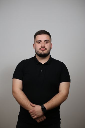 A portrait of a confident powerful caucasian man in a black t-shirt looking at the camera