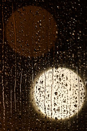 A beautiful shot of the raindrops on a window at night - perfect fo background