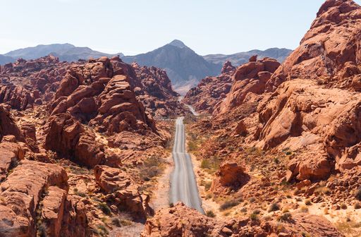 A landscape of a road surrounded by rock formations under the sunlight in Rainbow Vista, Nevada, the US
