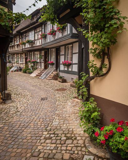 A vertical shot of Typical half-timbered houses lined along a pedestrian street in Germany