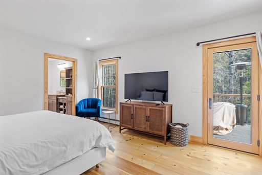 An interior view of a modern bedroom with a large bed and flat screen television